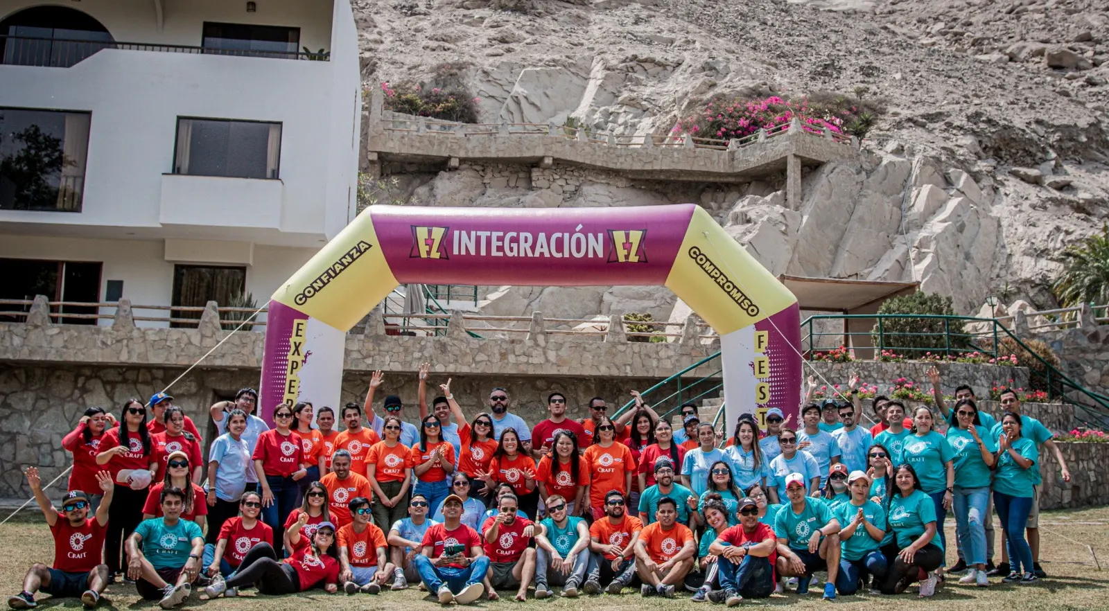 Foto grupal de los participantes de una jornada de integración bajo un arco inflable