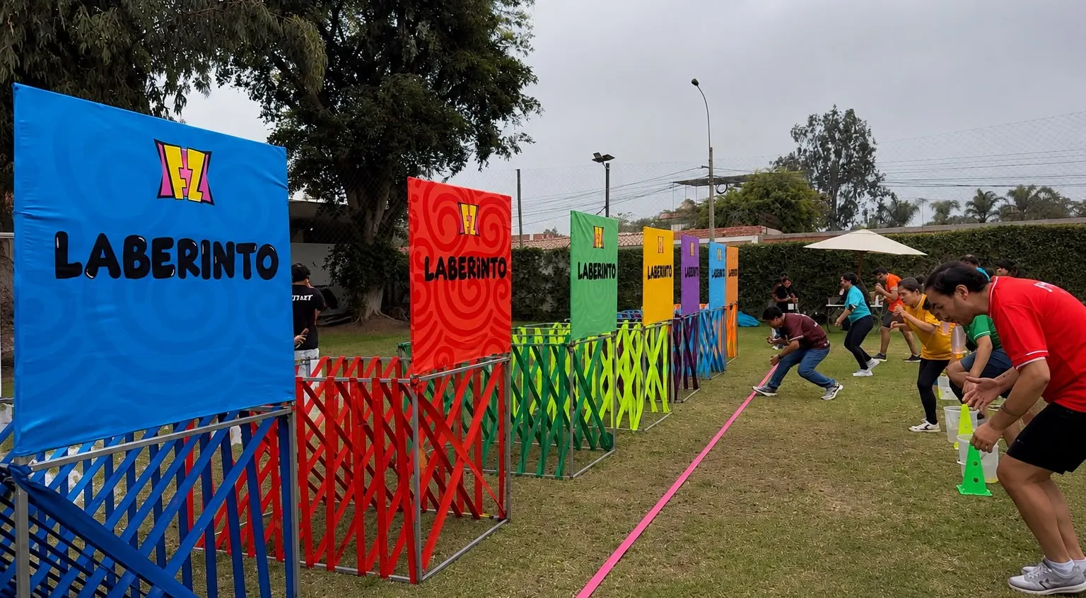 Participantes recorriendo un circuito de obstáculos de colores durante una gymkana