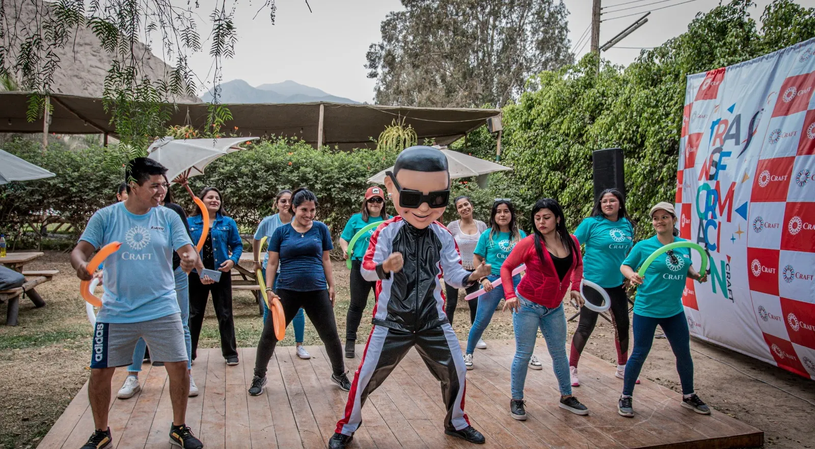 Un animador disfrazado dirige una coreografía sobre una tarima ante el público